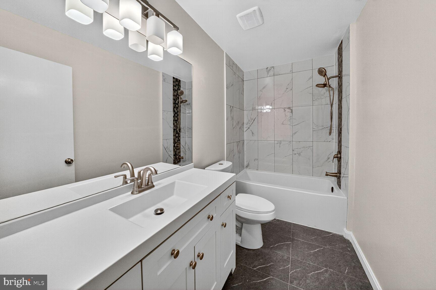 14507 Elmhan Court, Unit 182B Silver Spring, MD 20906 - Photo 12 of 21 a bathroom with a bathtub shower sink mirror vanity and toilet