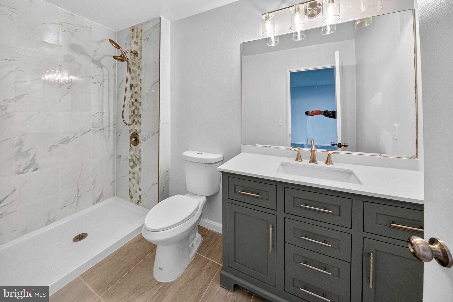 14507 Elmhan Court, Unit 182B Silver Spring, MD 20906 - Photo 19 of 21 a bathroom with a sink toilet a shower and a mirror