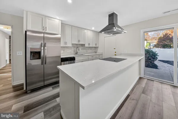 a kitchen with stainless steel appliances granite countertop a sink and a refrigerator