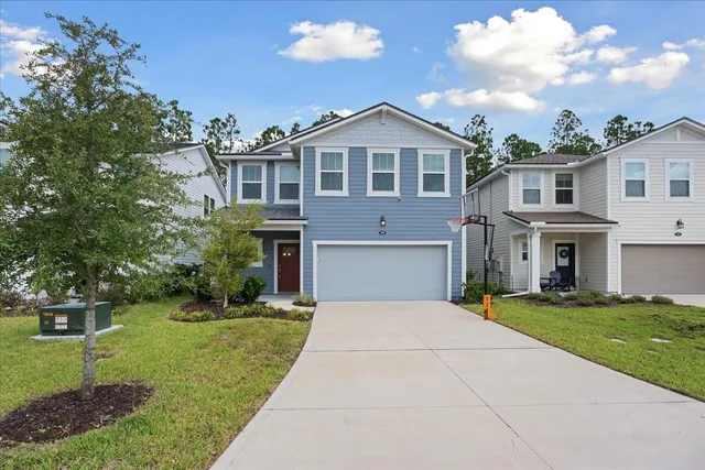a front view of a house with a yard and trees