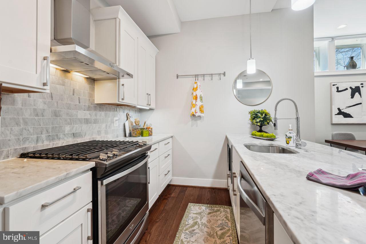 1401 K Street Southeast, Unit 1 Washington, DC 20003 - Photo 16 of 48 a kitchen with stainless steel appliances granite countertop a sink stove and cabinets