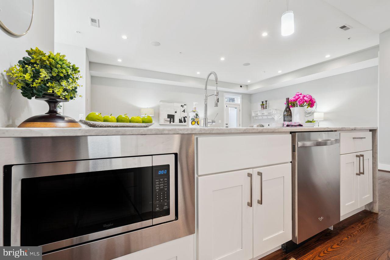 1401 K Street Southeast, Unit 1 Washington, DC 20003 - Photo 17 of 48 a kitchen with stainless steel appliances a stove a microwave and a potted plant