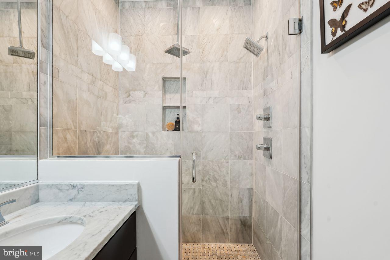 1401 K Street Southeast, Unit 1 Washington, DC 20003 - Photo 28 of 48 a bathroom with a granite countertop sink a mirror and shower