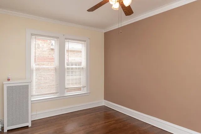 a view of an empty room with wooden floor closet and a window