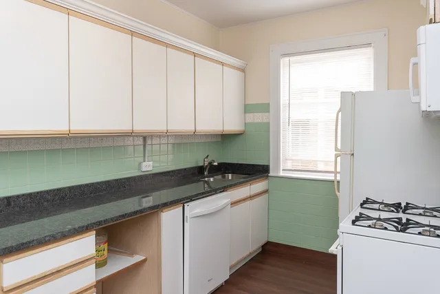 a kitchen with granite countertop a sink a stove and cabinets