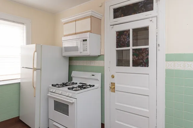 a white refrigerator freezer and a stove sitting inside of a kitchen