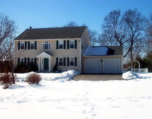 a front view of a house with a yard covered in snow