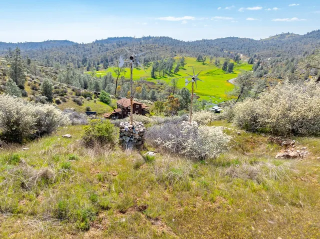 a kitchen with stainless steel appliances granite countertop a refrigerator a sink dishwasher a stove a dining table and chairs with wooden floor