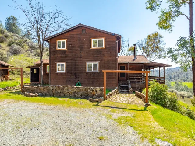 a view of a house with swimming pool and a small yard