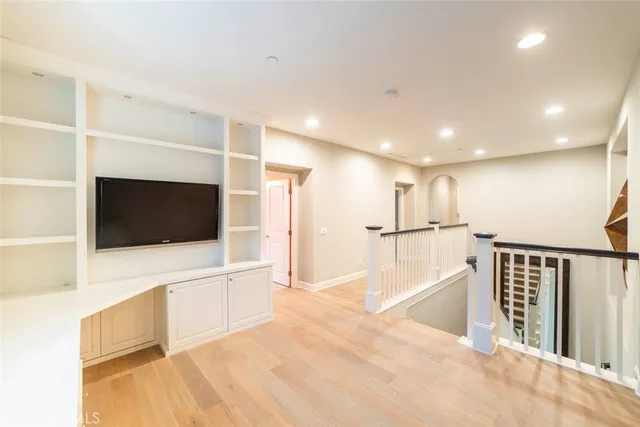 a view of a livingroom with wooden floor and a flat screen tv