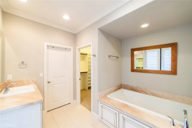 a bathroom with a tub sink and mirror