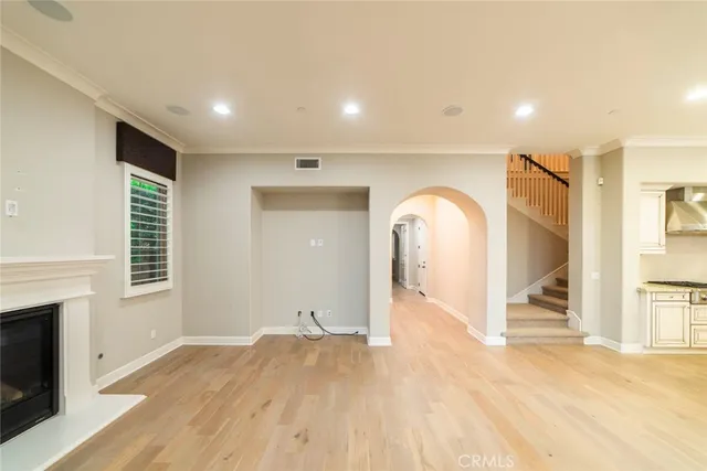 a view of empty room with wooden floor and fireplace