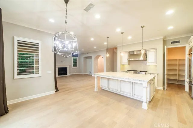 a large kitchen with kitchen island a stove a sink a center island and stainless steel appliances