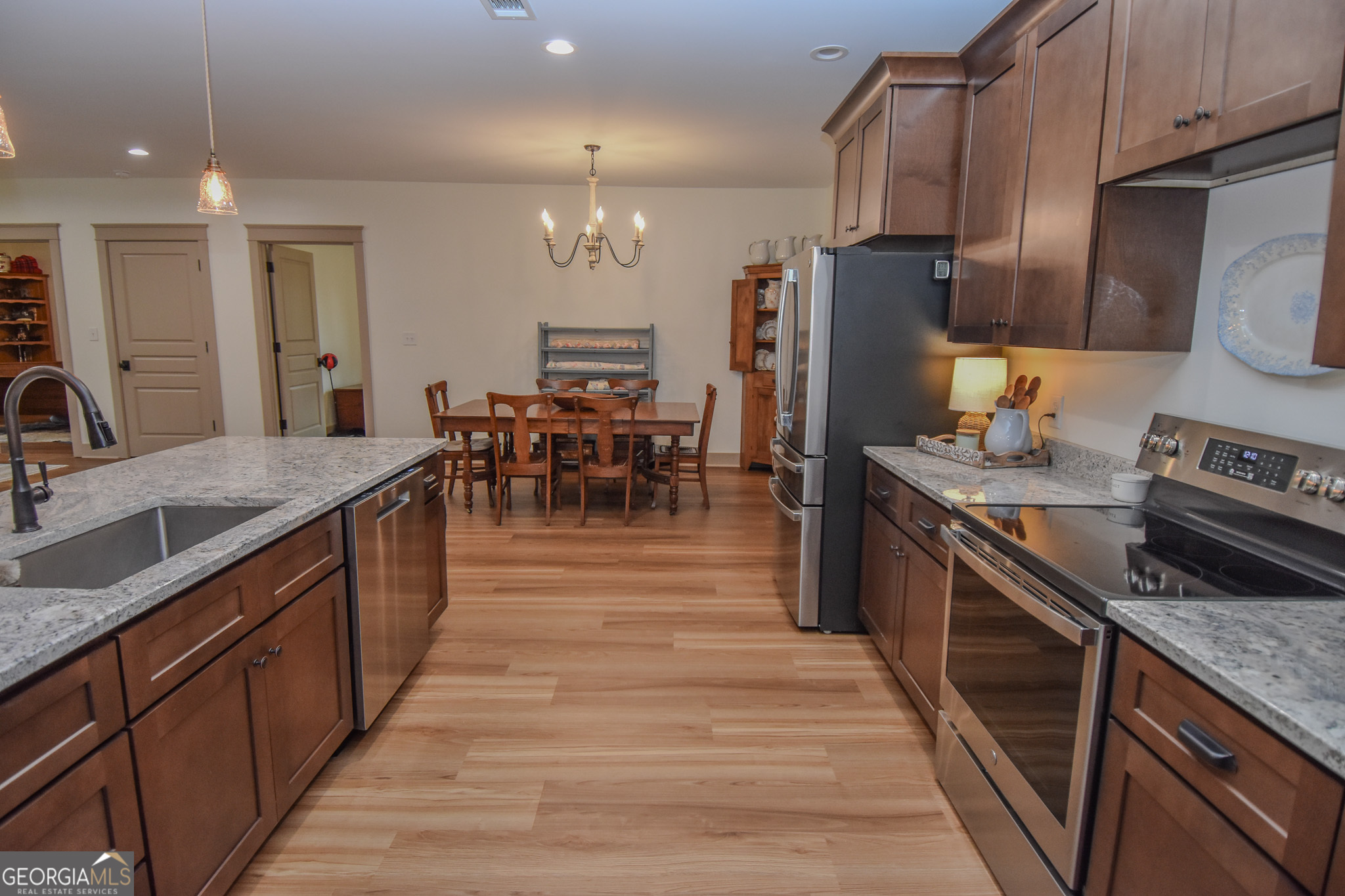 580-i B I B Howard Road Williamson, GA 30292 - Photo 21 of 123 a kitchen with stainless steel appliances granite countertop a stove top oven a sink dishwasher a dining table and chairs with wooden floor