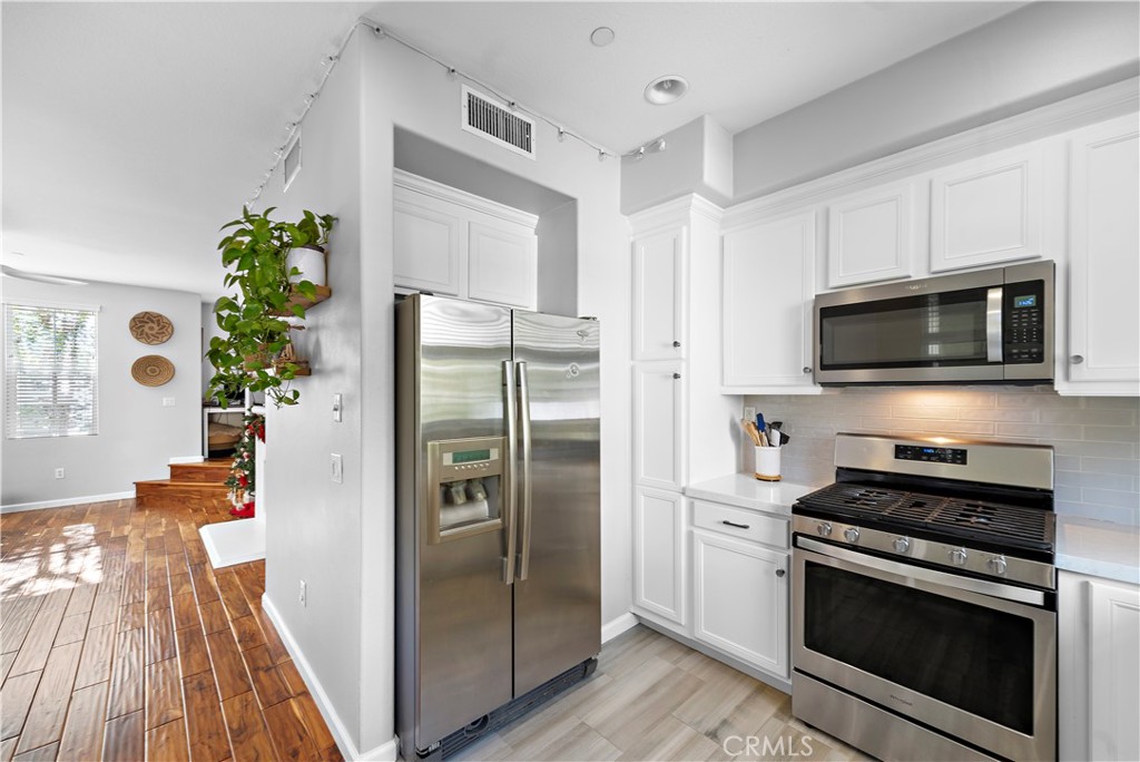 12 Triad Lane Ladera Ranch, CA 92694 - Photo 6 of 32 a kitchen with stainless steel appliances a stove a microwave and a refrigerator