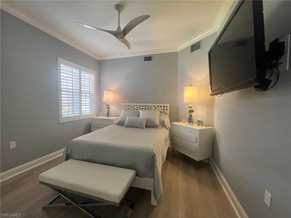 817 Regency Reserve Circle, Unit 3901 Naples, FL 34119 - Photo 17 of 35 Bedroom with crown molding, ceiling fan, and dark hardwood / wood-style flooring