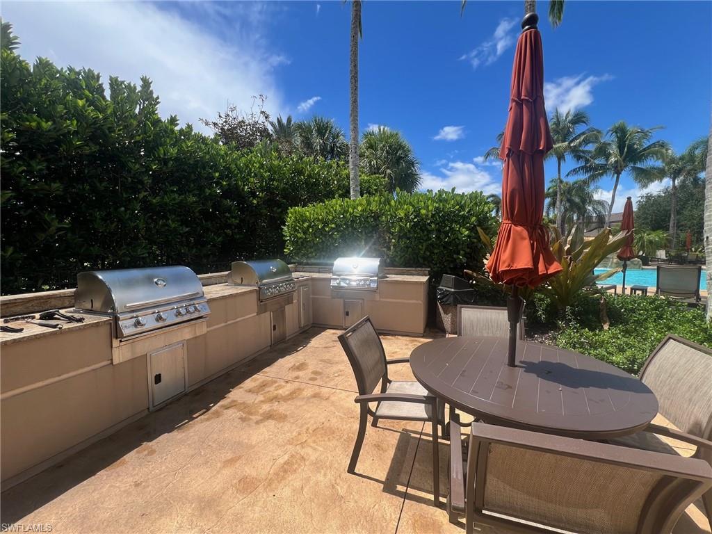 817 Regency Reserve Circle, Unit 3901 Naples, FL 34119 - Photo 26 of 35 View of community pool patio / terrace with a pool, a grill, and exterior kitchen