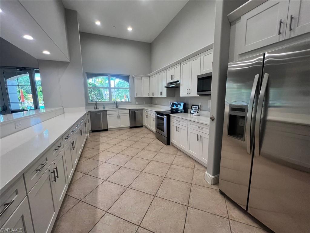 817 Regency Reserve Circle, Unit 3901 Naples, FL 34119 - Photo 28 of 35 Kitchen featuring stainless steel appliances, white cabinets, sink, and light tile floors