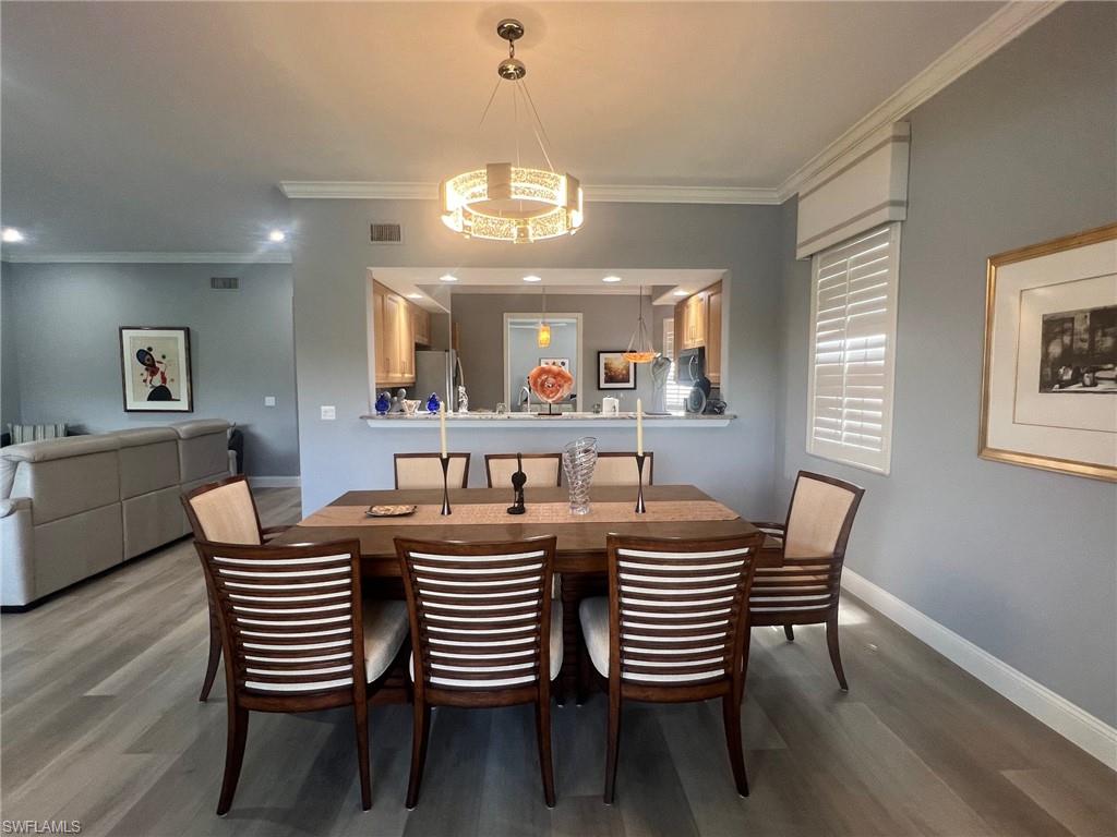 817 Regency Reserve Circle, Unit 3901 Naples, FL 34119 - Photo 3 of 35 Dining area featuring crown molding and hardwood / wood-style floors
