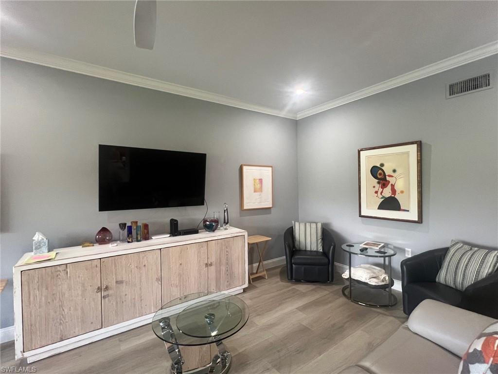 817 Regency Reserve Circle, Unit 3901 Naples, FL 34119 - Photo 8 of 35 Living room with ornamental molding and light hardwood / wood-style flooring