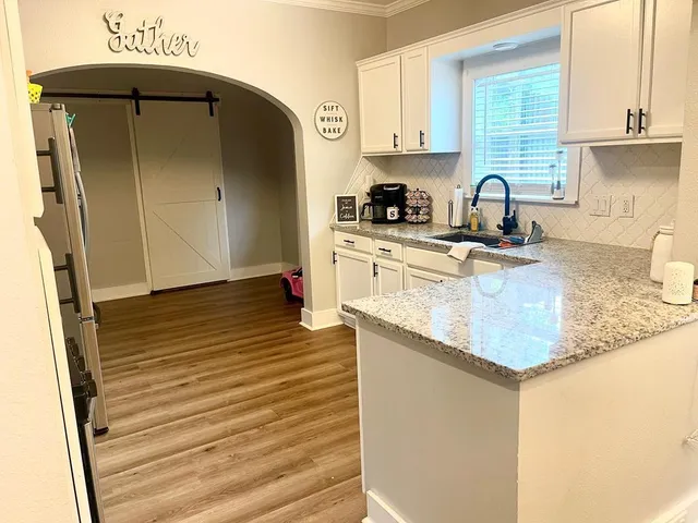 a kitchen with stainless steel appliances granite countertop a sink and a refrigerator