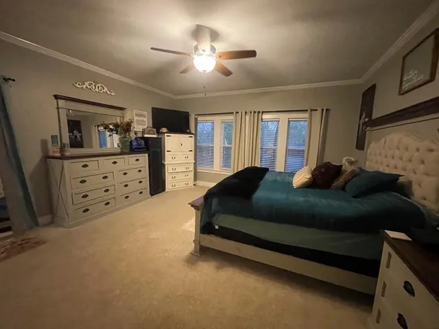 a spacious bedroom with a bed a dresser and a large mirror