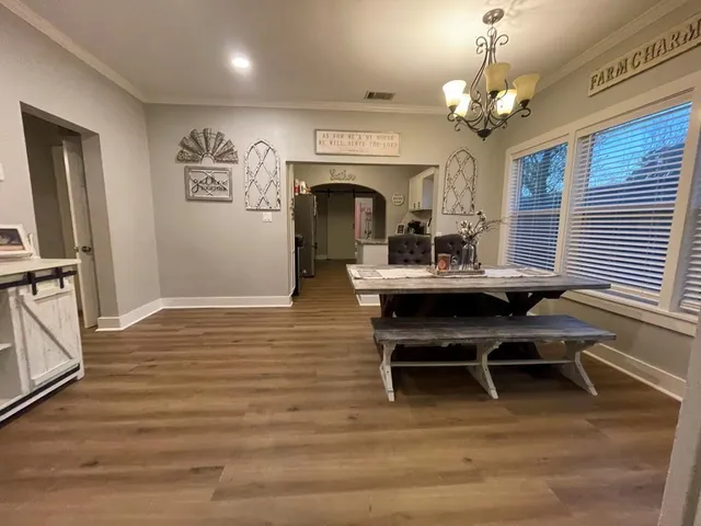 a view of a dining room with furniture wooden floor and a chandelier