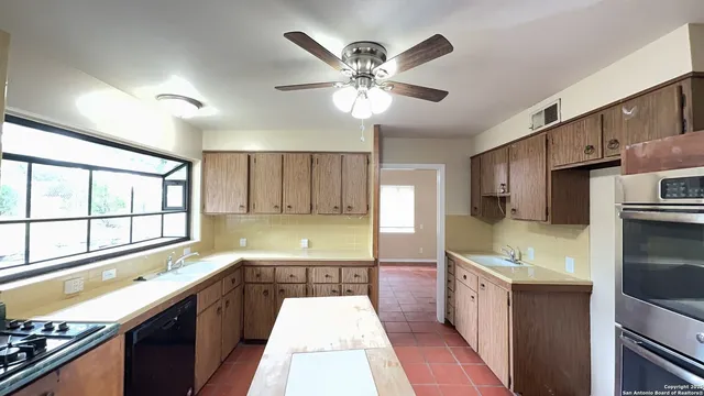 a kitchen with a sink appliances and cabinets