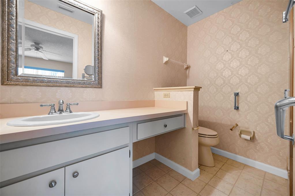 1481 Cairn Court Palm Harbor, FL 34683 - Photo 25 of 40 a bathroom with a granite countertop sink a toilet and a mirror