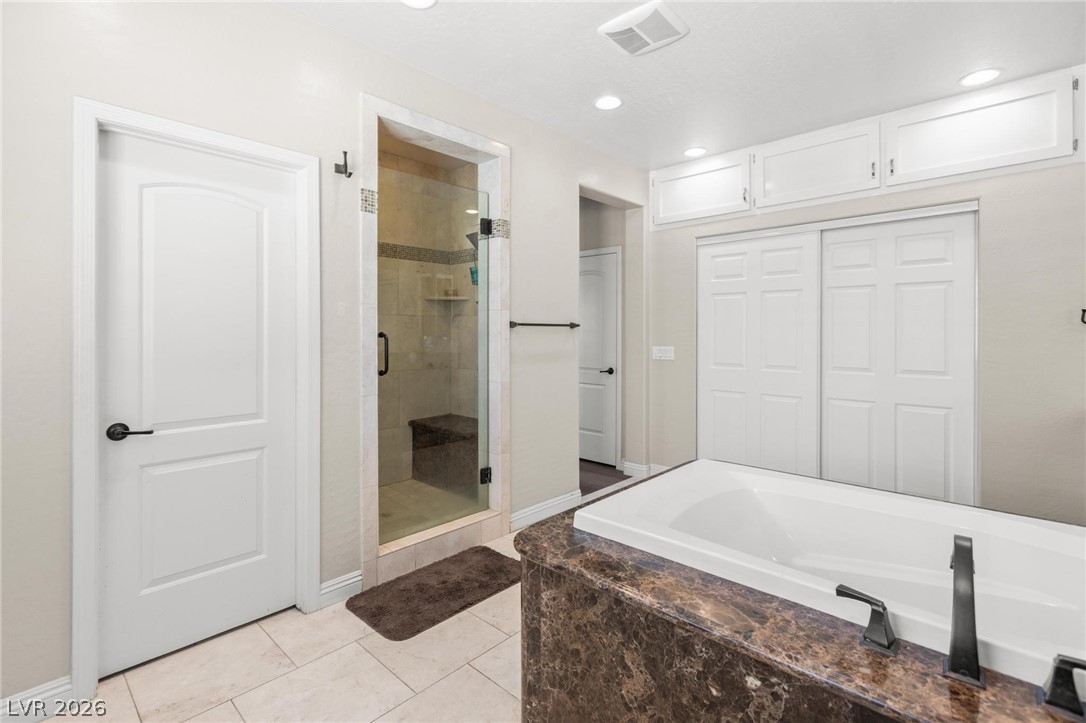 8431 Durango Ranch Court Las Vegas, NV 89113 - Photo 32 of 49 This spacious bathroom offers a relaxing soaking tub and a sleek glass-enclosed shower.