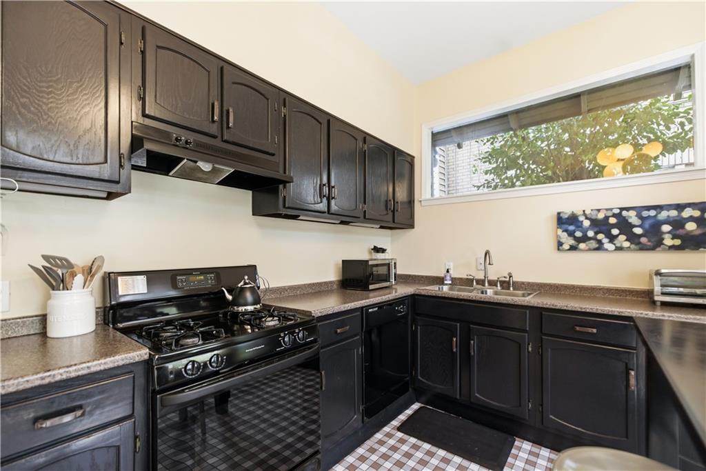 356 5th Street Northeast Atlanta, GA 30308 - Photo 12 of 54 a kitchen with stainless steel appliances a sink a stove and wooden cabinets