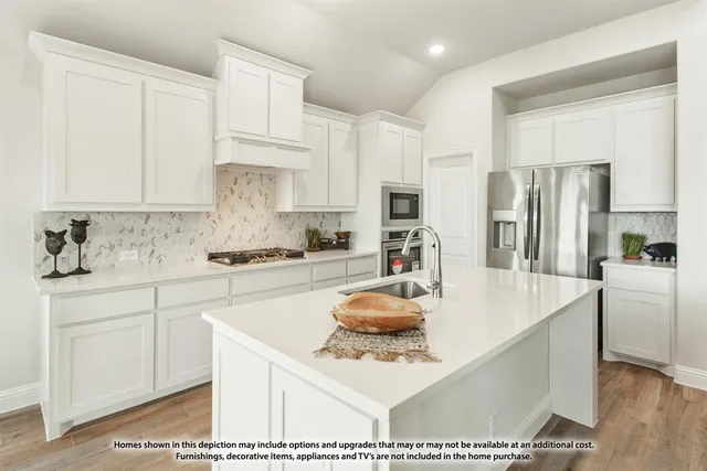 a kitchen with stainless steel appliances granite countertop a sink refrigerator and cabinets