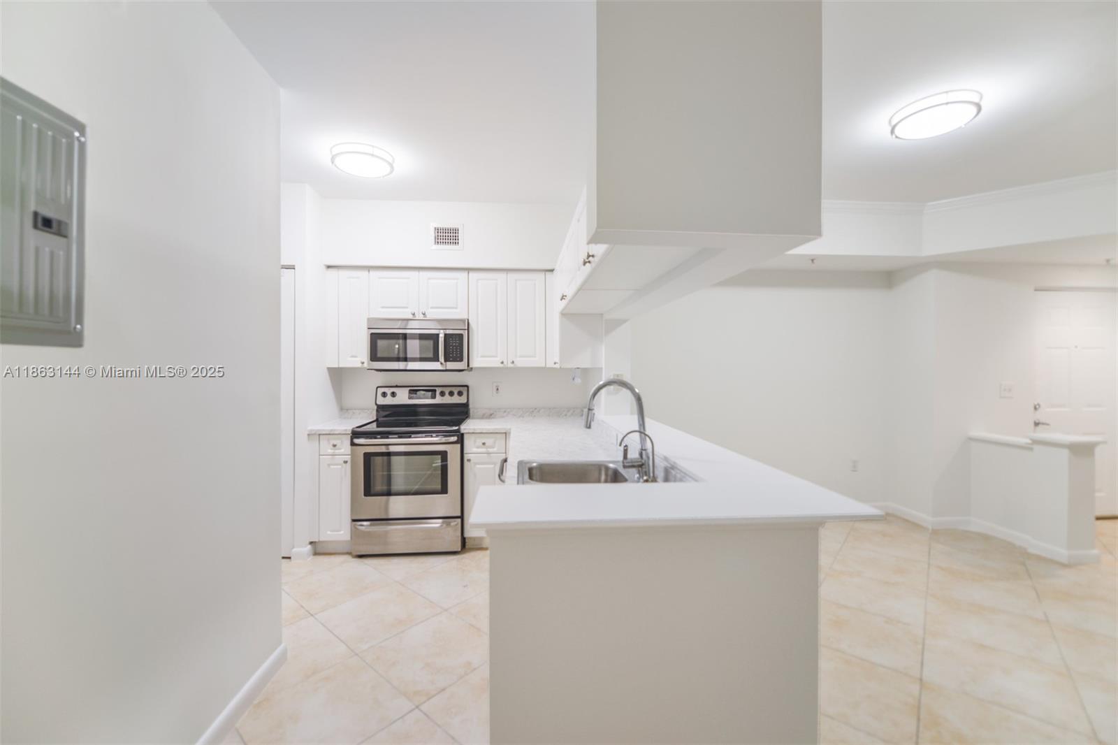 17100 North Bay Road, Unit 1303 Sunny Isles Beach, FL 33160 - Photo 3 of 24 a kitchen with stainless steel appliances granite countertop a sink and a refrigerator