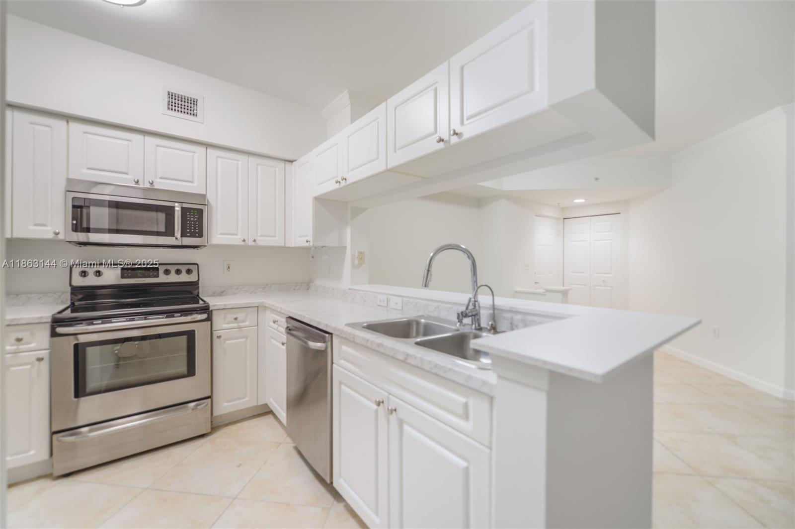17100 North Bay Road, Unit 1303 Sunny Isles Beach, FL 33160 - Photo 4 of 24 a kitchen with sink a microwave and cabinets