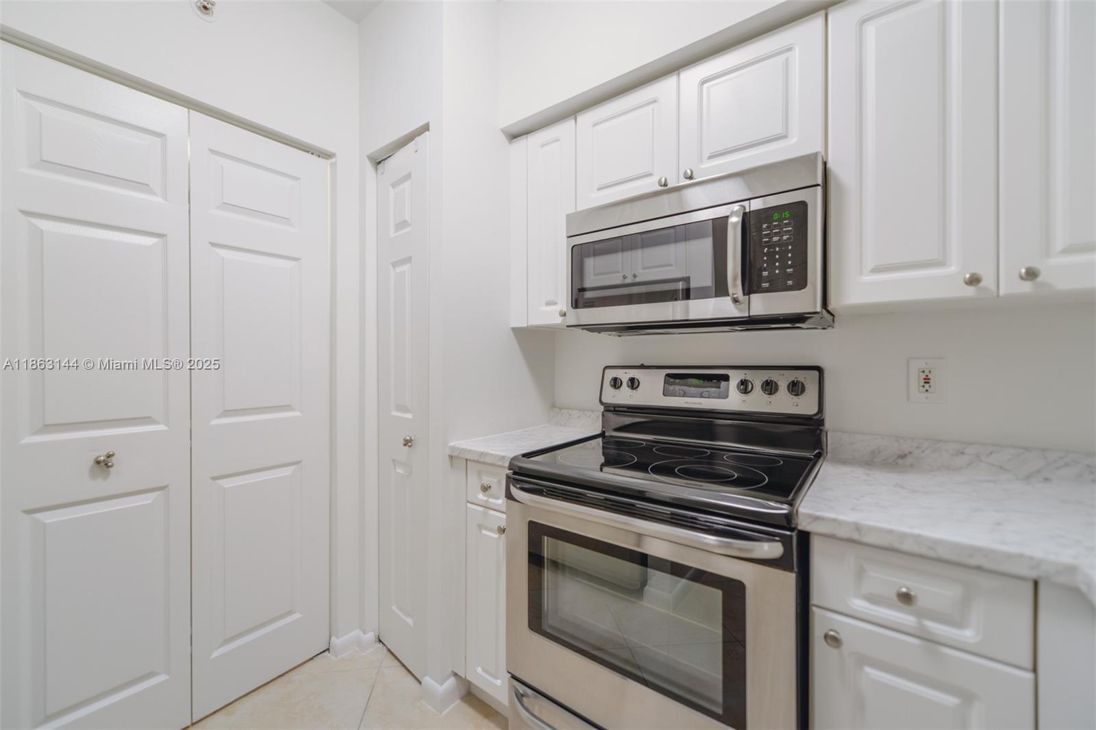 17100 North Bay Road, Unit 1303 Sunny Isles Beach, FL 33160 - Photo 5 of 24 a kitchen with cabinets and steel stainless steel appliances