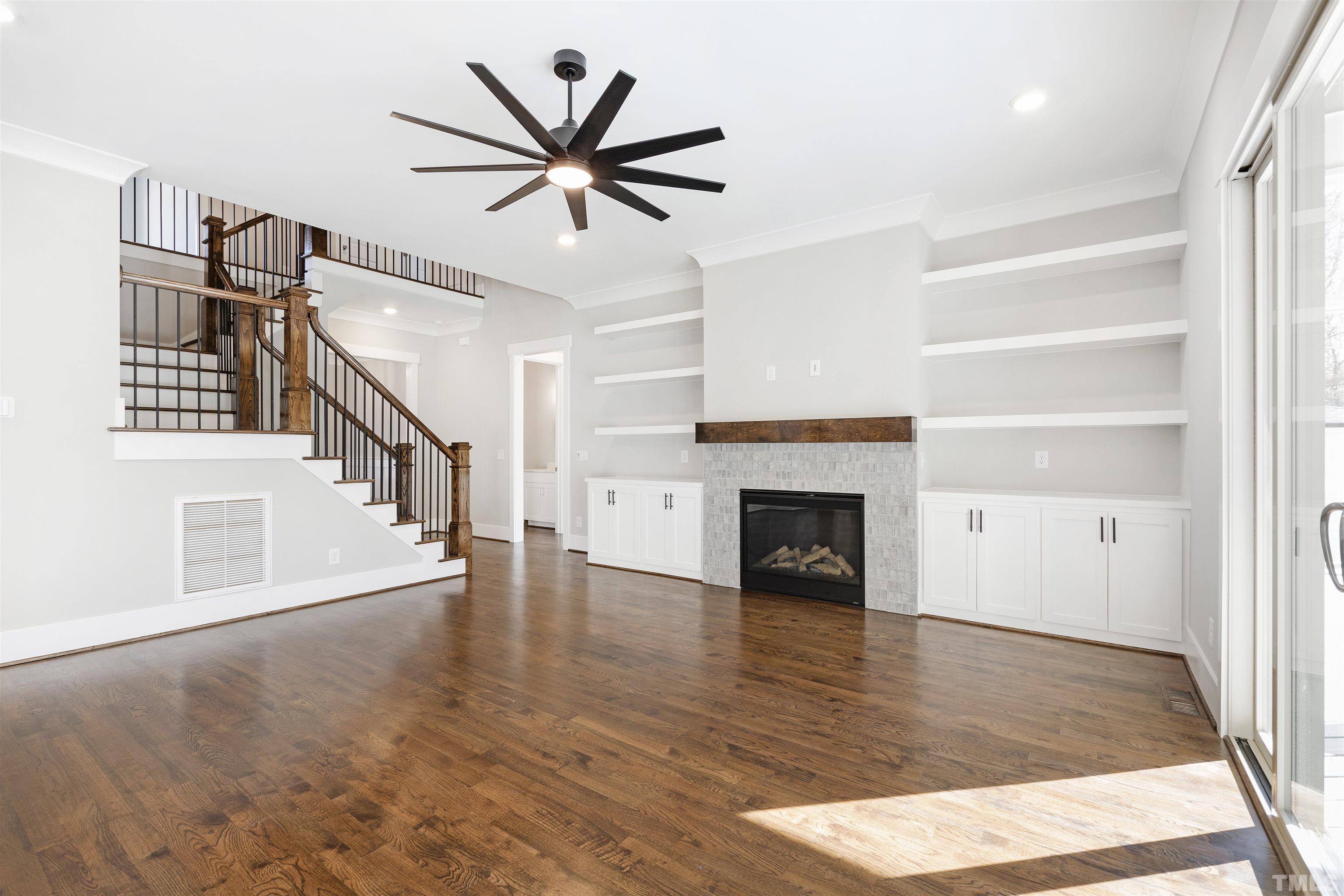 4013 Wilton Woods Place Cary, NC 27519 - Photo 2 of 30 a view of a livingroom with wooden floor a ceiling fan and windows