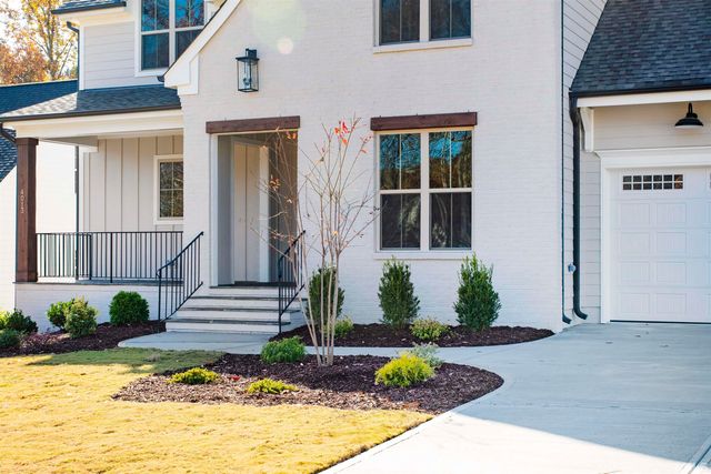 a front view of a house with a yard and potted plants