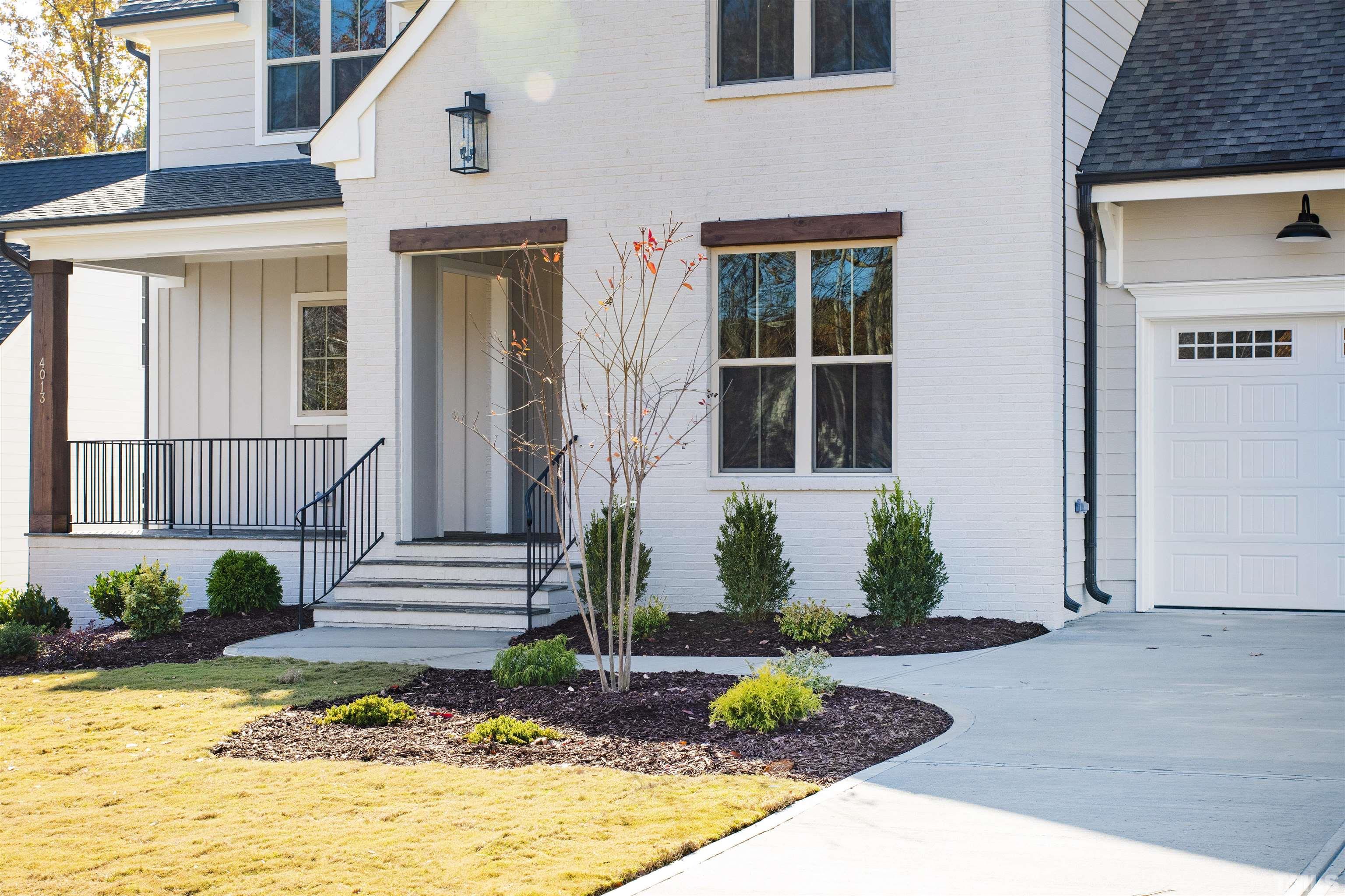 4013 Wilton Woods Place Cary, NC 27519 - Photo 29 of 30 a front view of a house with a yard and potted plants