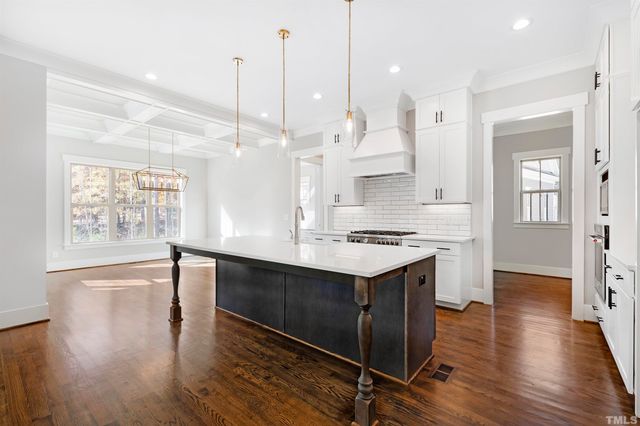 a large kitchen with lots of counter space a sink appliances and a large window