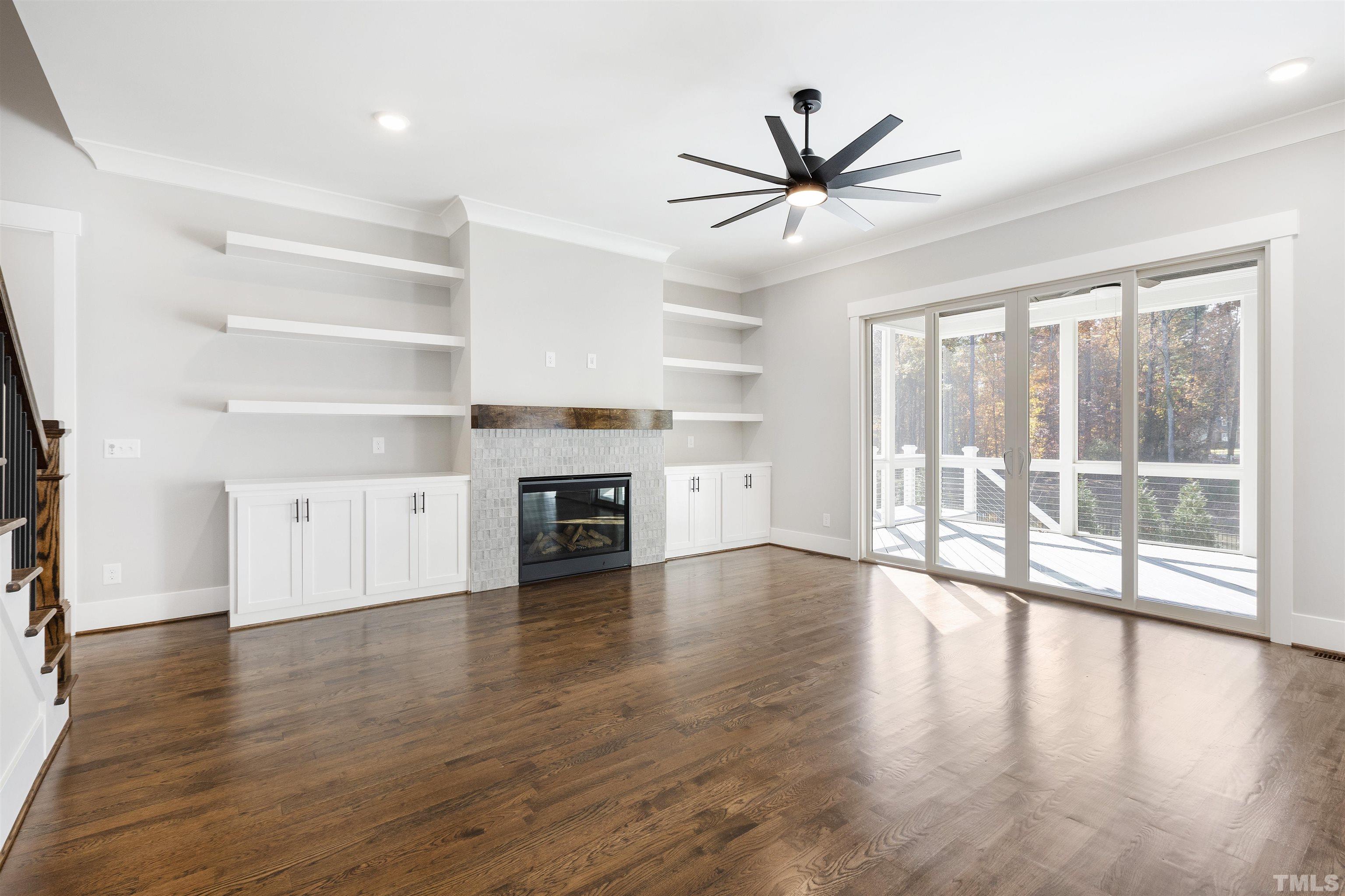 4013 Wilton Woods Place Cary, NC 27519 - Photo 10 of 30 a view of a livingroom with wooden floor a ceiling fan and windows