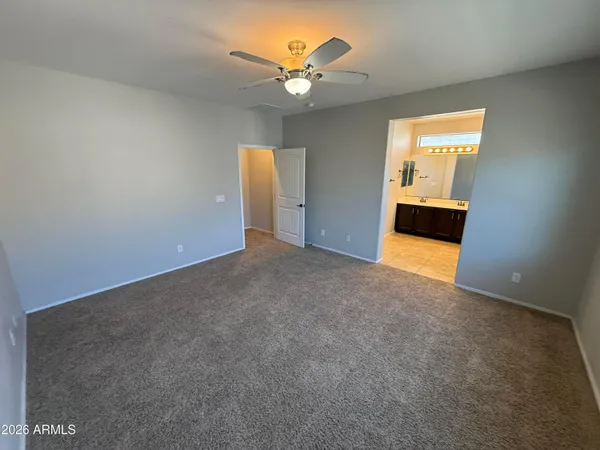 an empty room with a window and a ceiling fan