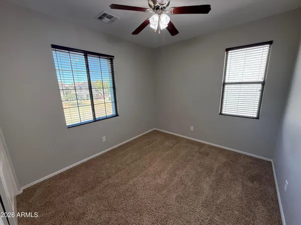 an empty room with windows and fan