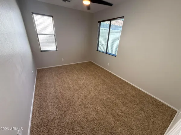 an empty room with windows and cabinet