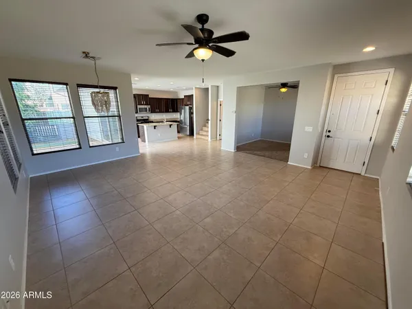 a view of an empty room with a fireplace and a chandelier fan