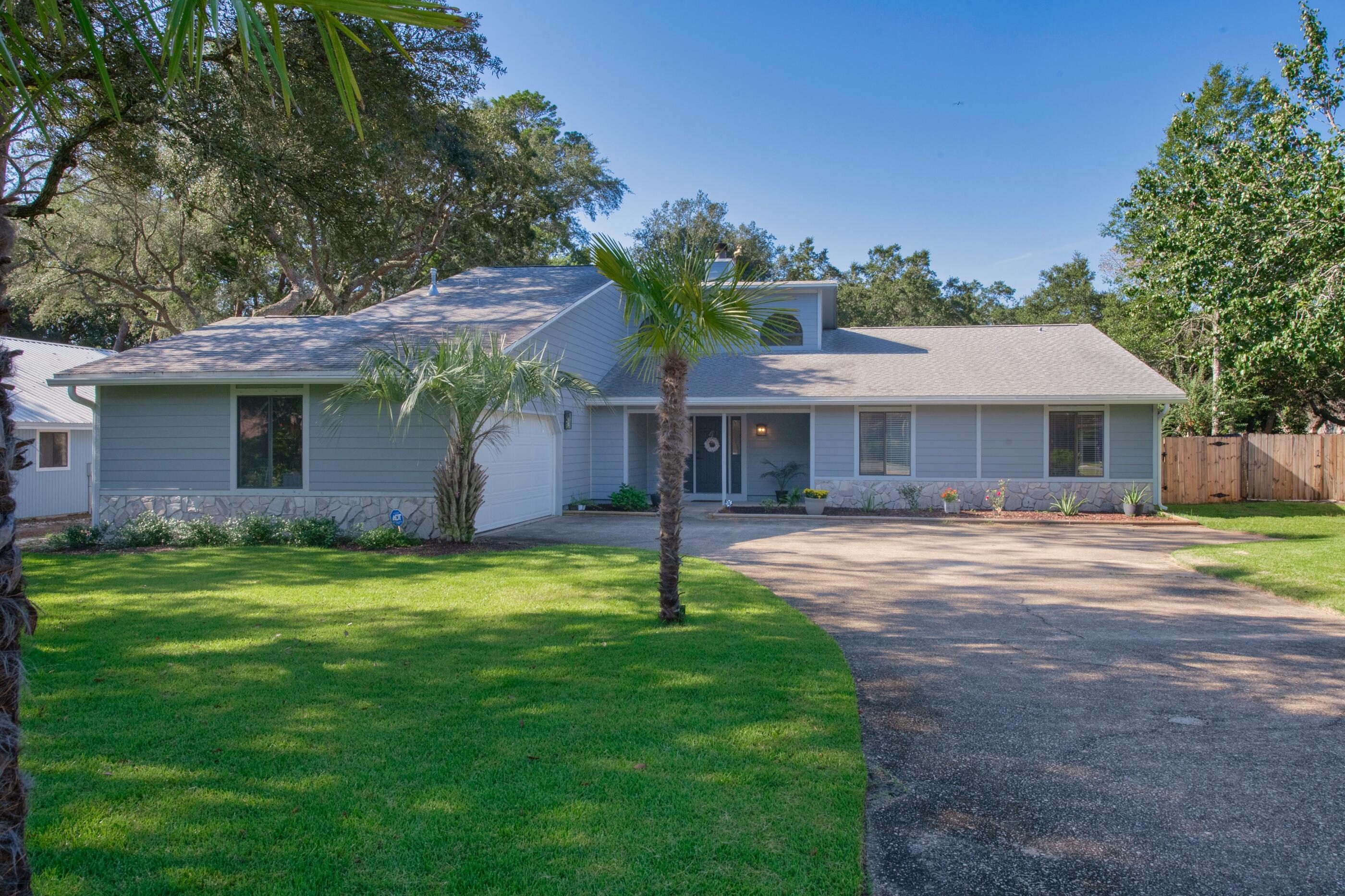 708 Caribbean Way Niceville, FL 32578 - Photo 2 of 42 a front view of a house with a garden