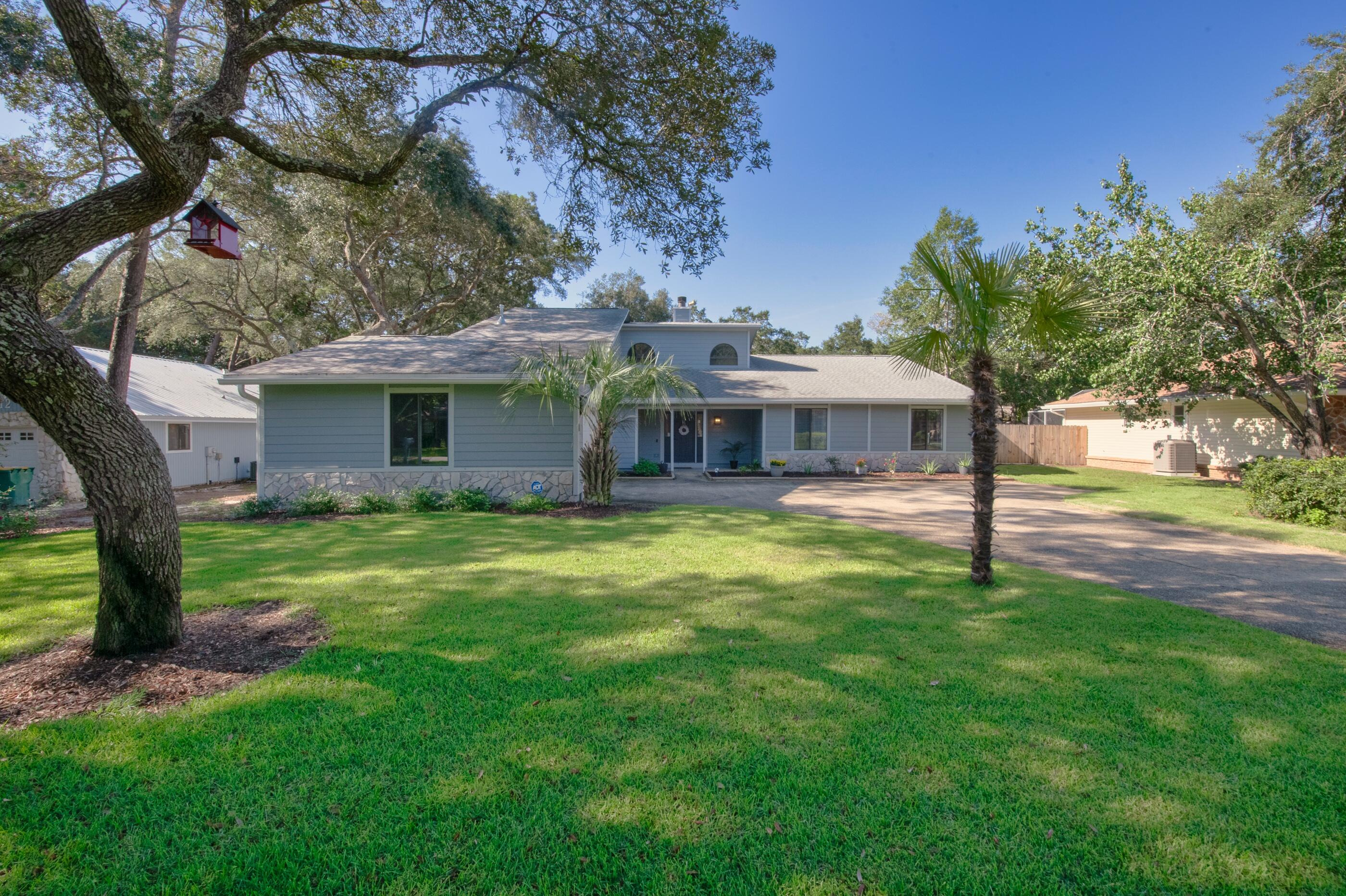 708 Caribbean Way Niceville, FL 32578 - Photo 4 of 42 a front view of a house with a garden