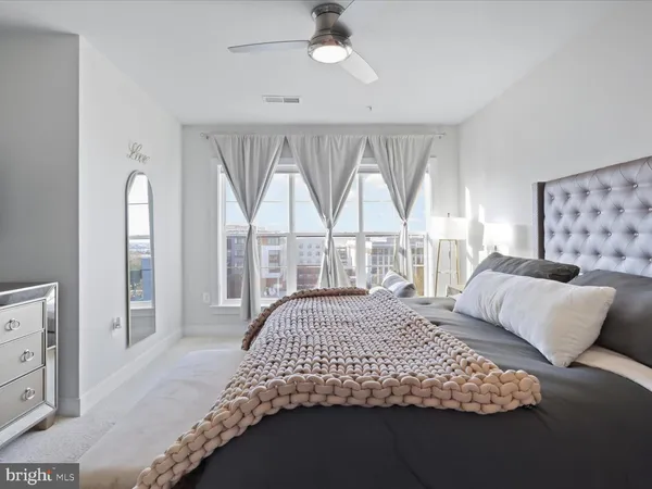 a bedroom with a bed and a large window