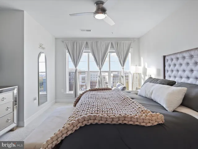 a bedroom with a bed and a large window