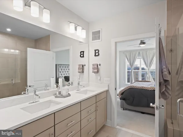 a en suite bathroom with a double vanity sink and a mirror