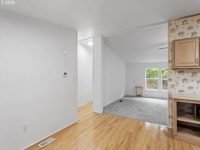 a view of empty room with a fireplace and wooden floor